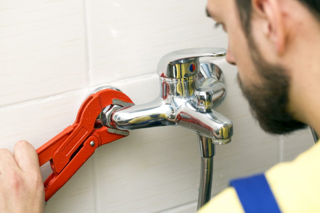 a man is fixing a faucet in a bathroom